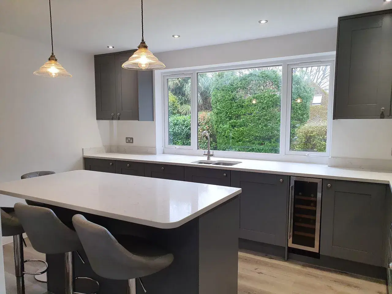 A kitchen with a large center island and bar stools.
