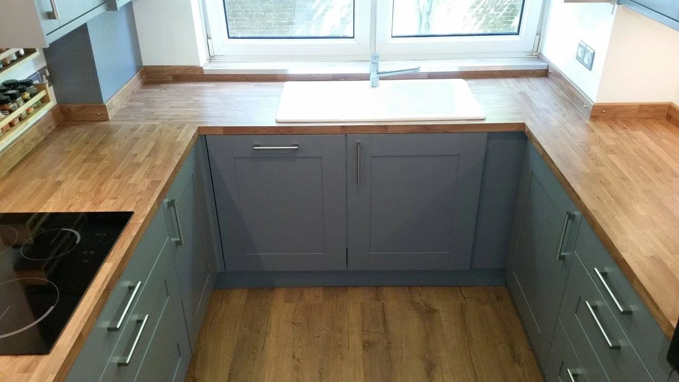 Wooden counter top with grey cupboards and drawers